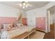 This adorable bedroom features a pink accent wall, white twin beds, and a ceiling fan at 5890 Vinyard Ln, Cumming, GA 30041