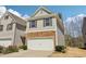 Charming two-story townhome featuring a stone facade and attached garage with manicured landscaping at 5890 Vinyard Ln, Cumming, GA 30041