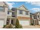 Charming two-story townhome featuring a stone facade and attached garage with manicured landscaping at 5890 Vinyard Ln, Cumming, GA 30041