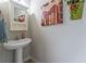 Cozy half bathroom featuring a pedestal sink and decorative wall art at 946 Gardenia Curv, Canton, GA 30114