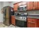 Kitchen with stainless steel appliances, wood cabinets, and contrasting countertops and backsplash at 946 Gardenia Curv, Canton, GA 30114