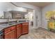 An open kitchen view featuring wood cabinets, dark countertops, and view into a bright dining area at 946 Gardenia Curv, Canton, GA 30114