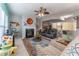 Bright living room with a fireplace, ceiling fan, colorful rug, and multiple seating options at 946 Gardenia Curv, Canton, GA 30114