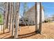 Backyard featuring trees, shrubs, and a staircase leading to a deck, blending nature and architecture at 2002 Stonewick Ct, Lawrenceville, GA 30043