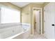 Bright bathroom featuring a soaking tub, tile accents, and ample natural light at 2002 Stonewick Ct, Lawrenceville, GA 30043
