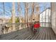 Outdoor deck with a table and chairs for outdoor dining and relaxation, surrounded by tall trees at 2002 Stonewick Ct, Lawrenceville, GA 30043