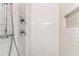 Close up of a shower with subway tile, modern fixtures, and decorative marble accent at 2002 Stonewick Ct, Lawrenceville, GA 30043