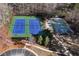 Aerial view of a well-maintained tennis and basketball court surrounded by trees at 2002 Stonewick Ct, Lawrenceville, GA 30043