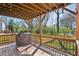 Inviting covered back deck with wood flooring, grill, and view of the lush backyard at 2108 Main Nw St, Atlanta, GA 30318