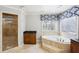 Bathroom with walk-in shower and a soaking tub under patterned window covering at 2108 Main Nw St, Atlanta, GA 30318