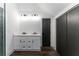 Modern bathroom featuring a double sink vanity with black hardware, wood floors, and large closet space at 6592 Factory Shoals Sw Rd, Mableton, GA 30126