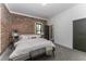 Stylish bedroom featuring an exposed brick accent wall, plush carpeting, and neutral decor at 6592 Factory Shoals Sw Rd, Mableton, GA 30126