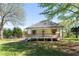 Charming exterior of home featuring a backyard with a wooden porch, a green yard, and mature trees at 6592 Factory Shoals Sw Rd, Mableton, GA 30126