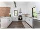 Contemporary kitchen featuring white cabinetry, stainless steel appliances, and hardwood flooring, with an exposed brick wall at 6592 Factory Shoals Sw Rd, Mableton, GA 30126