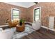 Cozy living room featuring an exposed brick wall, hardwood floors, stylish seating, and plenty of natural light at 6592 Factory Shoals Sw Rd, Mableton, GA 30126