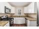 Well-lit kitchen featuring white cabinets, granite countertops, stainless steel appliances, and modern finishes at 2203 Knoll Dr, Decatur, GA 30032
