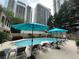 A community pool with lounge chairs and sun umbrellas with high rise buildings in the background at 244 13Th Ne St # 302, Atlanta, GA 30309
