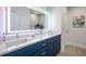 Modern bathroom with double sink vanity, blue cabinets, and illuminated mirror at 3165 Dogwood Dr # 107, Hapeville, GA 30354