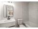 Bright bathroom featuring a white vanity, framed mirror, and shower with marble-look tiling at 3165 Dogwood Dr # 107, Hapeville, GA 30354