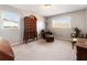 Sunlit bedroom featuring a comfortable leather chaise lounge, a traditional armoire, and carpet floors at 6784 Tilton Ln, Peachtree Corners, GA 30360