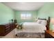 A comfortable bedroom with a large window, dresser, and a classic wooden frame bed at 6784 Tilton Ln, Peachtree Corners, GA 30360