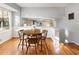 Sunlit dining area with wood floors and table, with view to the living room at 6784 Tilton Ln, Peachtree Corners, GA 30360