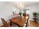 Cozy dining room with a chandelier, wood table, and chairs with a view into the kitchen and living room at 6784 Tilton Ln, Peachtree Corners, GA 30360