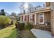 Close-up of home's brick facade, entry with a storm door and lush lawn at 6784 Tilton Ln, Peachtree Corners, GA 30360