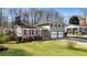 Charming two-story home with a brick facade, red shutters, a well-manicured lawn, and an attached two-car garage at 6784 Tilton Ln, Peachtree Corners, GA 30360