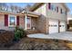 Inviting front entrance with brick accents, a two-car garage, and classic architectural details at 6784 Tilton Ln, Peachtree Corners, GA 30360