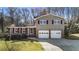 Charming home featuring a well-manicured lawn, two car garage, and a mix of siding and brick at 6784 Tilton Ln, Peachtree Corners, GA 30360