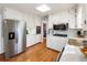 Kitchen with stainless steel refrigerator, white cabinets, hardwood flooring, and modern appliances at 6784 Tilton Ln, Peachtree Corners, GA 30360