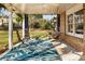Relaxing covered patio with hanging swing, comfortable seating, and a view of the backyard at 6784 Tilton Ln, Peachtree Corners, GA 30360