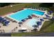 Aerial view of a community pool with lounge chairs, tables, umbrellas, and a diving board at 6784 Tilton Ln, Peachtree Corners, GA 30360