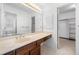 Bright bathroom with large mirror, a sink with dark wood cabinets, and a doorway to a closet with shelves at 1522 Wood Valley Dr, Marietta, GA 30066