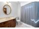 Bathroom features single sink with dark vanity, a round mirror, and a bathtub with shower curtain at 1522 Wood Valley Dr, Marietta, GA 30066