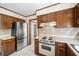 Well-equipped kitchen with stainless steel refrigerator, wood cabinets, and tile flooring at 1522 Wood Valley Dr, Marietta, GA 30066