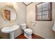 Elegant powder room with pedestal sink, decorative mirror, and window with natural light at 1522 Wood Valley Dr, Marietta, GA 30066