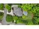 Aerial view of a home with a unique roof design, surrounded by lush greenery and a backyard pool at 2260 Wood Falls Dr, Cumming, GA 30041