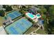 An aerial shot of community amenities: pools, tennis courts and basketball court amid beautiful landscaping at 2260 Wood Falls Dr, Cumming, GA 30041