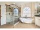 Elegant bathroom featuring a standalone tub, glass-enclosed shower, and neutral tilework at 2260 Wood Falls Dr, Cumming, GA 30041