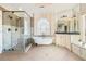 Luxurious bathroom featuring a soaking tub under a leaded glass window and a glass enclosed shower at 2260 Wood Falls Dr, Cumming, GA 30041