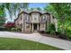 Exterior of a luxury home with a stone facade, well-manicured lawn, and mature landscaping at 2260 Wood Falls Dr, Cumming, GA 30041