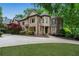 Stately stone home with manicured lawn, mature trees, and circular driveway at 2260 Wood Falls Dr, Cumming, GA 30041