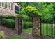 View of a stone gate and wrought iron fence enclosing the verdant lawn at 2260 Wood Falls Dr, Cumming, GA 30041