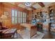 Executive home office with custom wood trim, built-in bookshelves, hardwood floors, and abundant natural light at 2260 Wood Falls Dr, Cumming, GA 30041