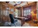 Elegant office features rich wood paneling, coffered ceiling, and a cozy reading nook at 2260 Wood Falls Dr, Cumming, GA 30041