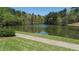Scenic view of a tranquil pond with grassy banks and trees in a serene setting at 2260 Wood Falls Dr, Cumming, GA 30041