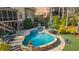 Beautiful in-ground pool and spa with stone surround and patio area, with lush landscaping at 2260 Wood Falls Dr, Cumming, GA 30041