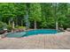 Backyard swimming pool featuring a sun shelf, stone waterfall feature, and paved patio area at 2260 Wood Falls Dr, Cumming, GA 30041